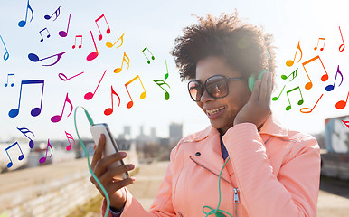 Image showing happy young woman with smartphone and headphones