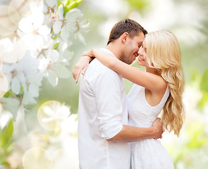 Image showing happy couple hugging over blooming summer garden