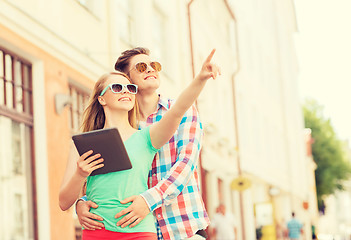 Image showing smiling couple with tablet pc in city