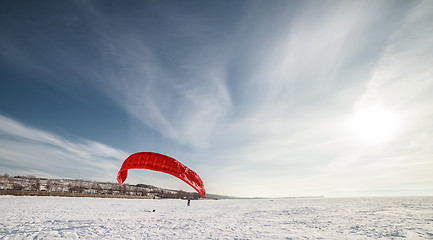 Image showing Kiteboarder with blue kite on the snow