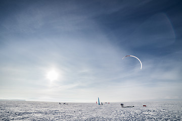 Image showing Kiteboarder with blue kite on the snow