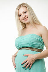 Image showing Portrait of a pregnant young girl hugging belly