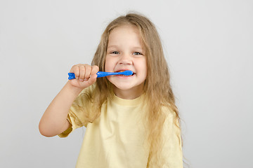 Image showing Four-year girl brushing her teeth