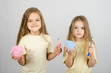 Image showing Two sisters brush your teeth