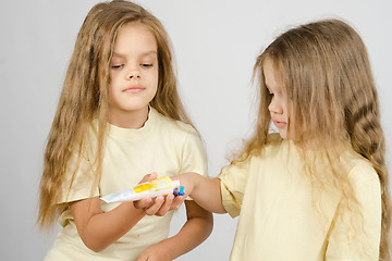 Image showing Girl squeezing toothpaste from a tube sister