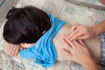 Image showing doctor therapists taps the back of a young patient