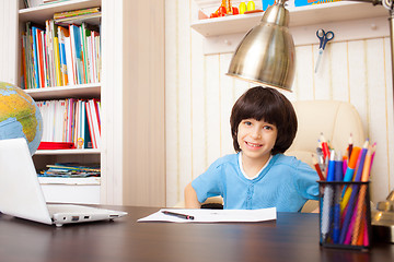 Image showing smiling schoolboy doing homework