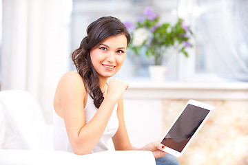 Image showing smiling young girl reading  tablet