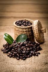 Image showing pile of fresh beans and green leaves and spoon in jar