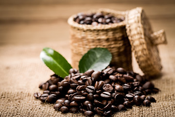 Image showing pile of fresh beans and green leaves and spoon in jar