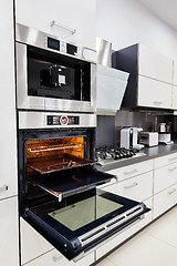 Image showing Modern custom hi-tek kitchen, oven with open door