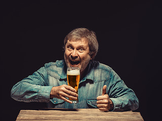 Image showing The smiling man in denim shirt with glass of beer