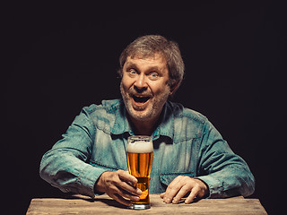Image showing The smiling man in denim shirt with glass of beer