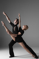 Image showing two young modern ballet dancers on gray studio background 