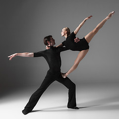 Image showing two young modern ballet dancers on gray studio background 