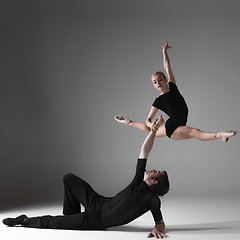 Image showing two young modern ballet dancers on gray studio background 