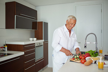 Image showing man cooking at home preparing salad in kitchen