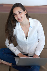 Image showing relaxed young woman at home working on laptop computer