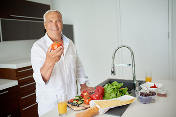 Image showing man cooking at home preparing salad in kitchen