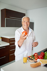 Image showing man cooking at home preparing salad in kitchen