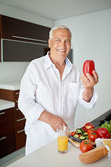 Image showing man cooking at home preparing salad in kitchen