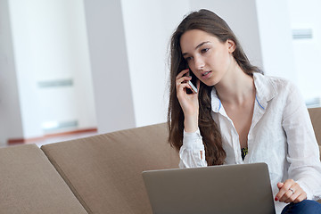 Image showing relaxed young woman at home working on laptop computer