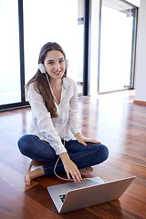 Image showing relaxed young woman at home working on laptop computer