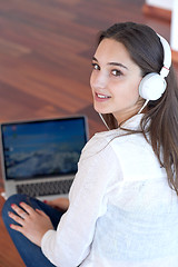 Image showing relaxed young woman at home working on laptop computer