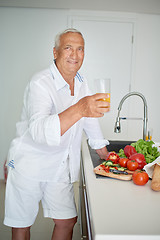 Image showing man cooking at home preparing salad in kitchen