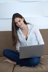 Image showing relaxed young woman at home working on laptop computer