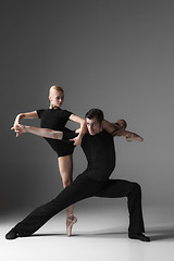 Image showing two young modern ballet dancers on gray studio background 