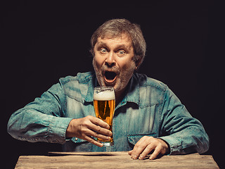 Image showing The screaming man in denim shirt with glass of beer