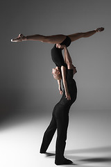 Image showing two young modern ballet dancers on gray studio background 