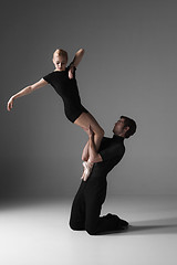 Image showing two young modern ballet dancers on gray studio background 