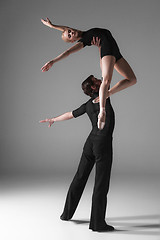 Image showing two young modern ballet dancers on gray studio background 