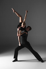 Image showing two young modern ballet dancers on gray studio background 