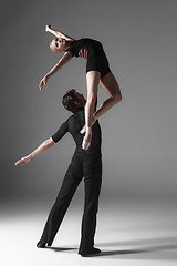 Image showing two young modern ballet dancers on gray studio background 