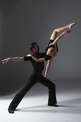 Image showing two young modern ballet dancers on gray studio background 