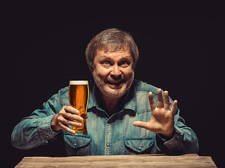 Image showing The smiling man in denim shirt with glass of beer