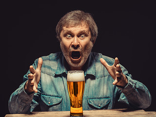 Image showing The screaming man in denim shirt with glass of beer