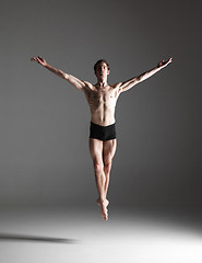 Image showing The young attractive modern ballet dancer jumping on white background