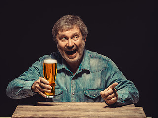 Image showing The screaming man in denim shirt with glass of beer