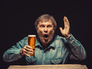 Image showing The enchanted and emotional fan with glass of beer