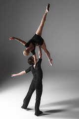 Image showing two young modern ballet dancers on gray studio background 