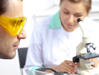 Image showing scientist in protective yellow sunglasses and his colleague in l