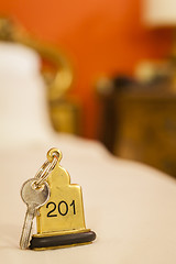 Image showing Hotel Room Key lying on Bed with keyring