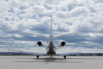 Image showing Aircraft learjet Plane in front of the Airport with cloudy sky