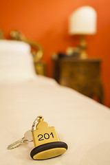 Image showing Hotel Room Key lying on Bed with keyring