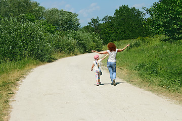 Image showing Mother and daughter walking by rural road