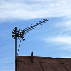 Image showing TV antenna over old roof